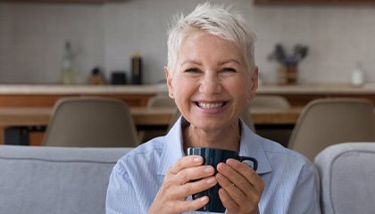 Woman smiling while holding a coffee mug