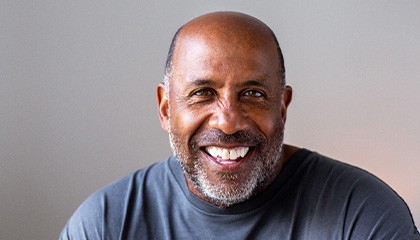 Closeup of man smiling in blue shirt