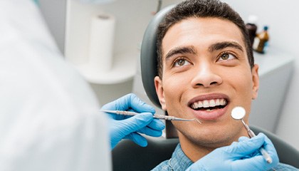 Man smiling at dentist about to examine his teeth