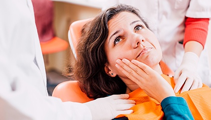 A woman with a toothache visiting her dentist